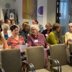 Keskikäytävän oikea puoli. Etupenkki tyhjänä esiintyjiä varten.